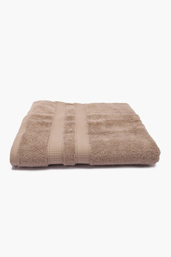 Folded beige cotton towel on a white background