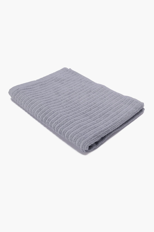 Folded light grey textured cotton towel on white background