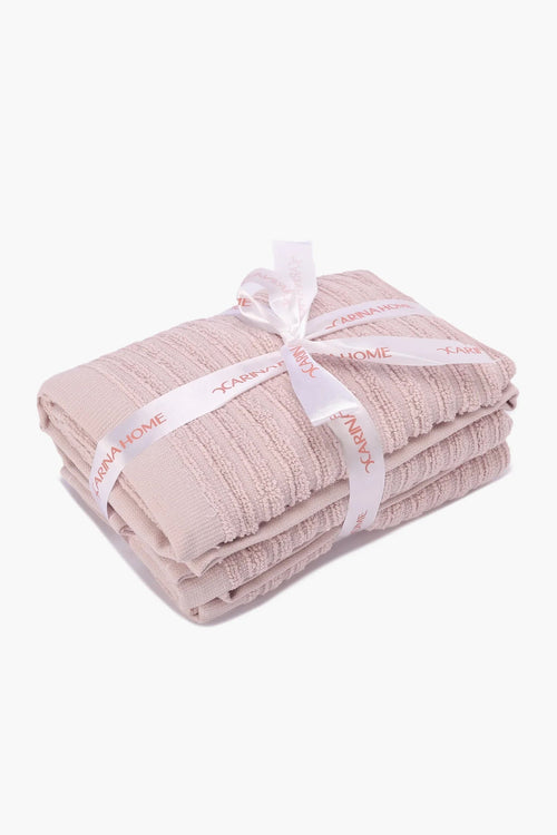 Folded beige textured towels tied with a white ribbon, soft cotton bath towel set