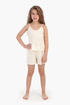 Girl wearing sleeveless cream cotton pajama set with subtle yellow patterns