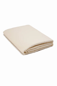 Folded beige cotton bedsheet on a white background, soft and minimal bedding
