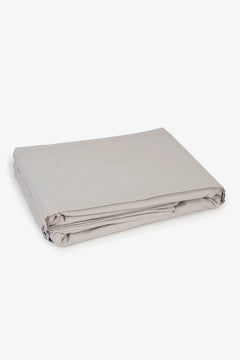 Folded beige cotton bed sheet on a white background