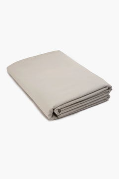 Folded beige cotton bedsheet on white background, soft and smooth finish
