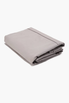Folded light grey cotton bed sheet on a white background