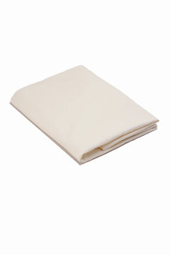 Folded cream cotton fabric or bedsheet on white background