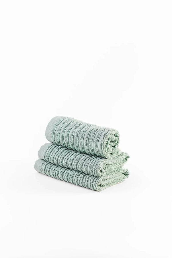 Stack of three soft mint green ribbed towels on white background