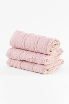 Stack of three soft pink cotton towels on a white background