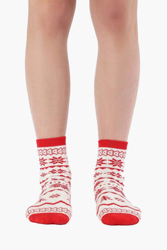 Red and white cotton socks with Nordic snowflake pattern on woman's feet