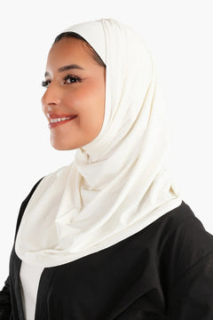 Smiling woman in a white cotton hijab and black outerwear, side profile on white background