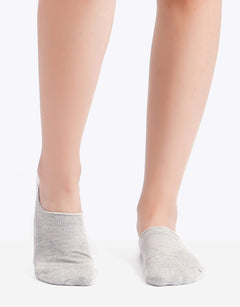 Light grey cotton ankle socks on feet, soft low-cut women's socks, plain background