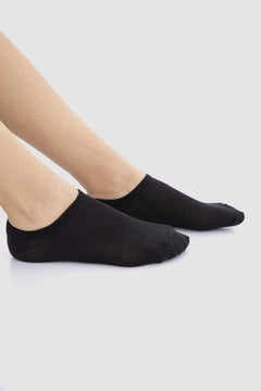 Black cotton ankle socks worn on feet, minimalist background, comfortable everyday wear