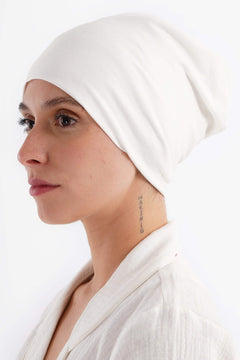 Woman wearing a soft white cotton hijab bandana in side view
