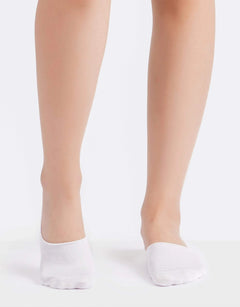 Woman wearing white cotton invisible socks on a plain background
