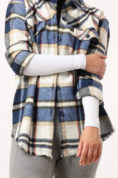 Woman wearing detachable white arm sleeves under a plaid flannel shirt and grey pants