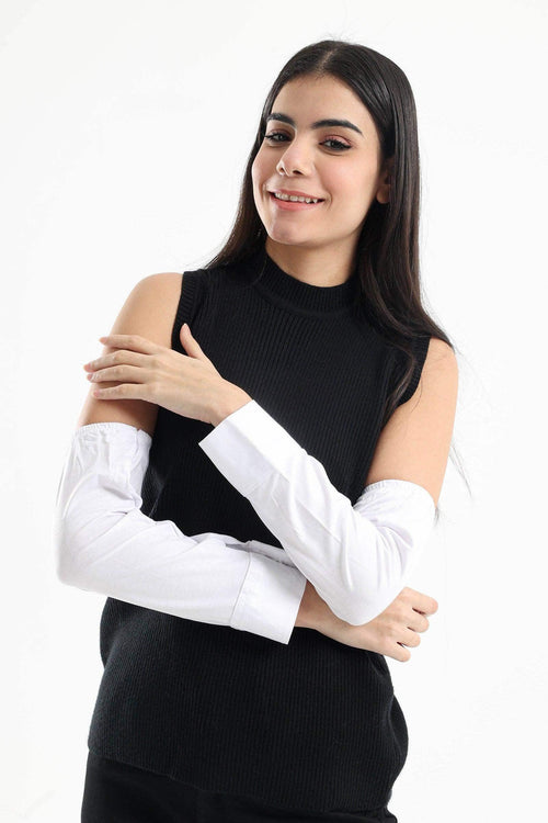 Woman wearing detachable white sleeves with buttoned cuffs and black sleeveless top