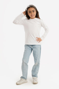 Girl wearing white long sleeve top, light blue jeans, and white sneakers on white background