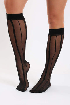 Sheer black knee-high socks with vertical stripes, worn by a woman on a white background.