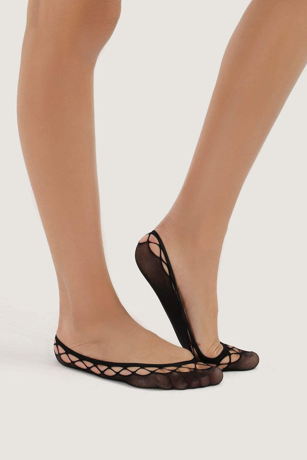 Women's feet wearing black net invisible socks with mesh design on a neutral background