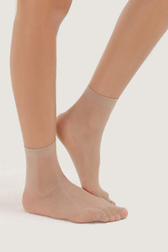 Beige sheer short-length stretch socks on female feet, lightweight and comfortable style.