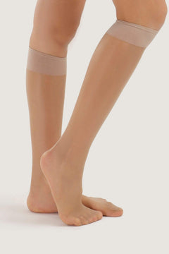 Sheer nude knee-high socks with wide elastic band on women's legs